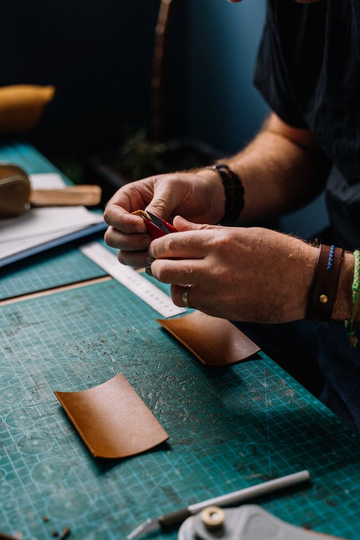 A Close-Up Shot of a Man Cutting a Leather